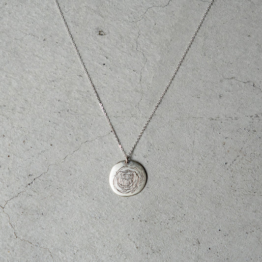 Melanie DeCourcey  Round silver pendant with scribbles