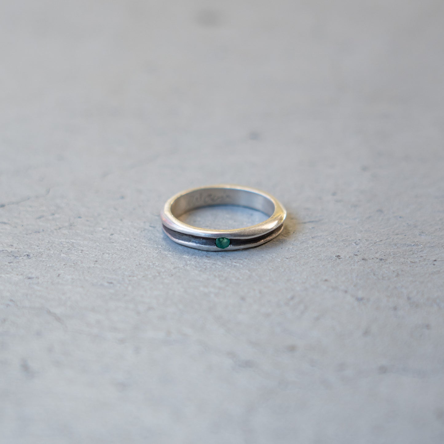 Melanie Decourcey Thin silver ring with oxidized groove and emerald