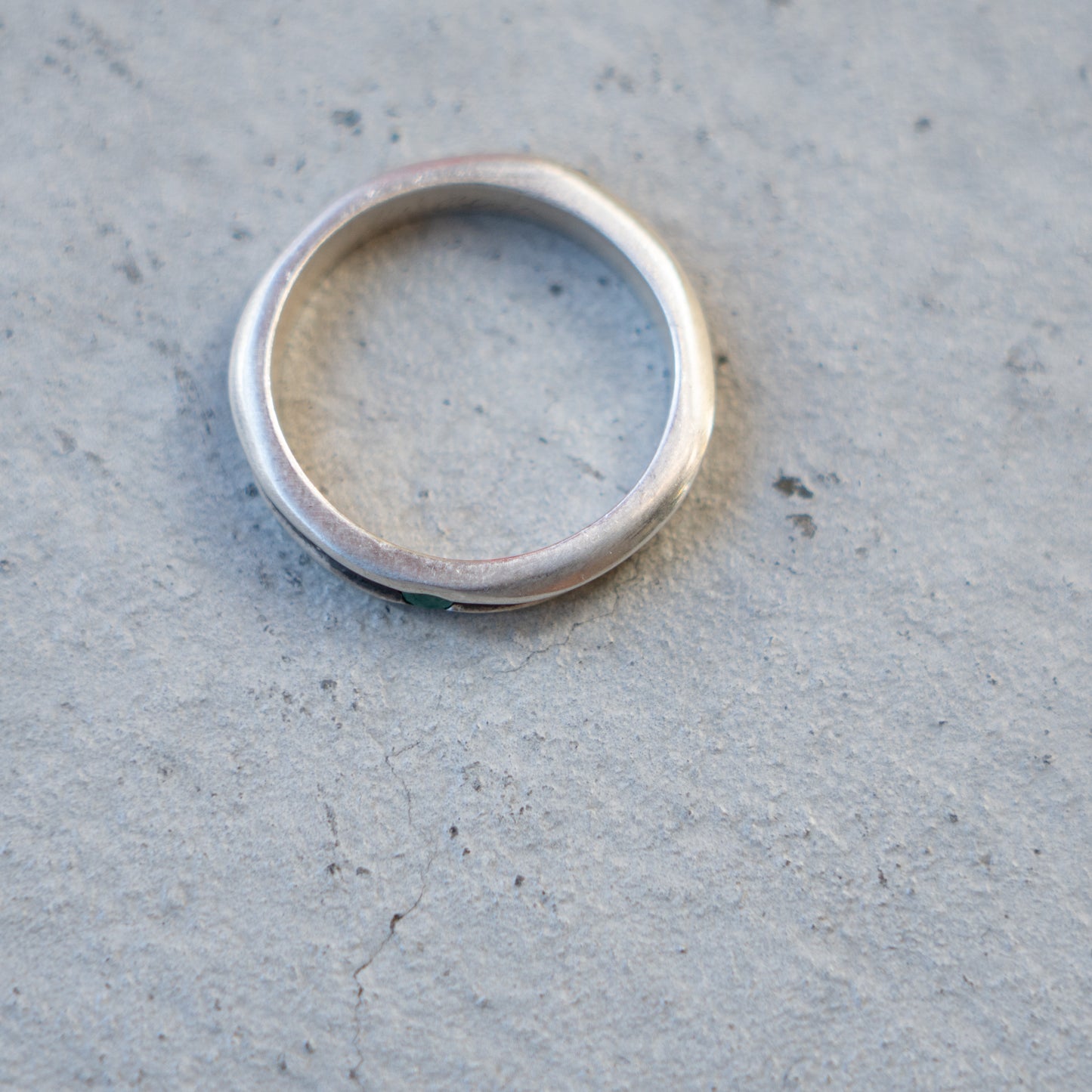 Melanie Decourcey Thin silver ring with oxidized groove and emerald