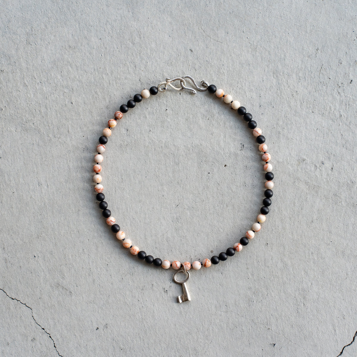 Melanie DeCourcey   Marble, matt onyx and spinel with silver key pendant