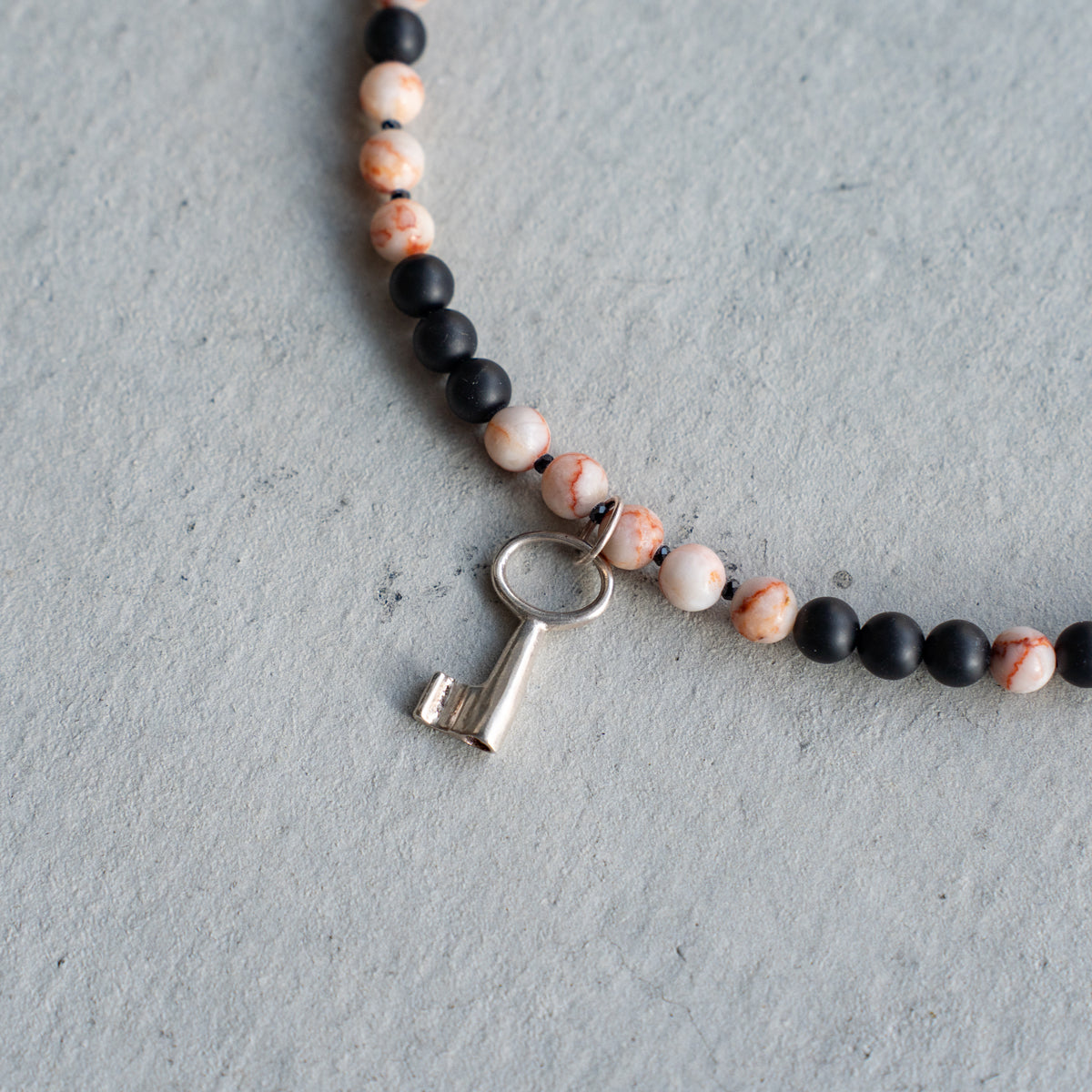 Melanie DeCourcey   Marble, matt onyx and spinel with silver key pendant