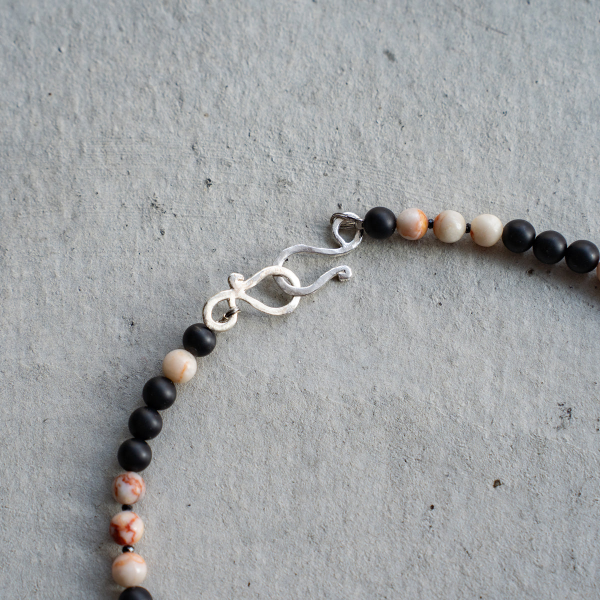 Melanie DeCourcey   Marble, matt onyx and spinel with silver key pendant