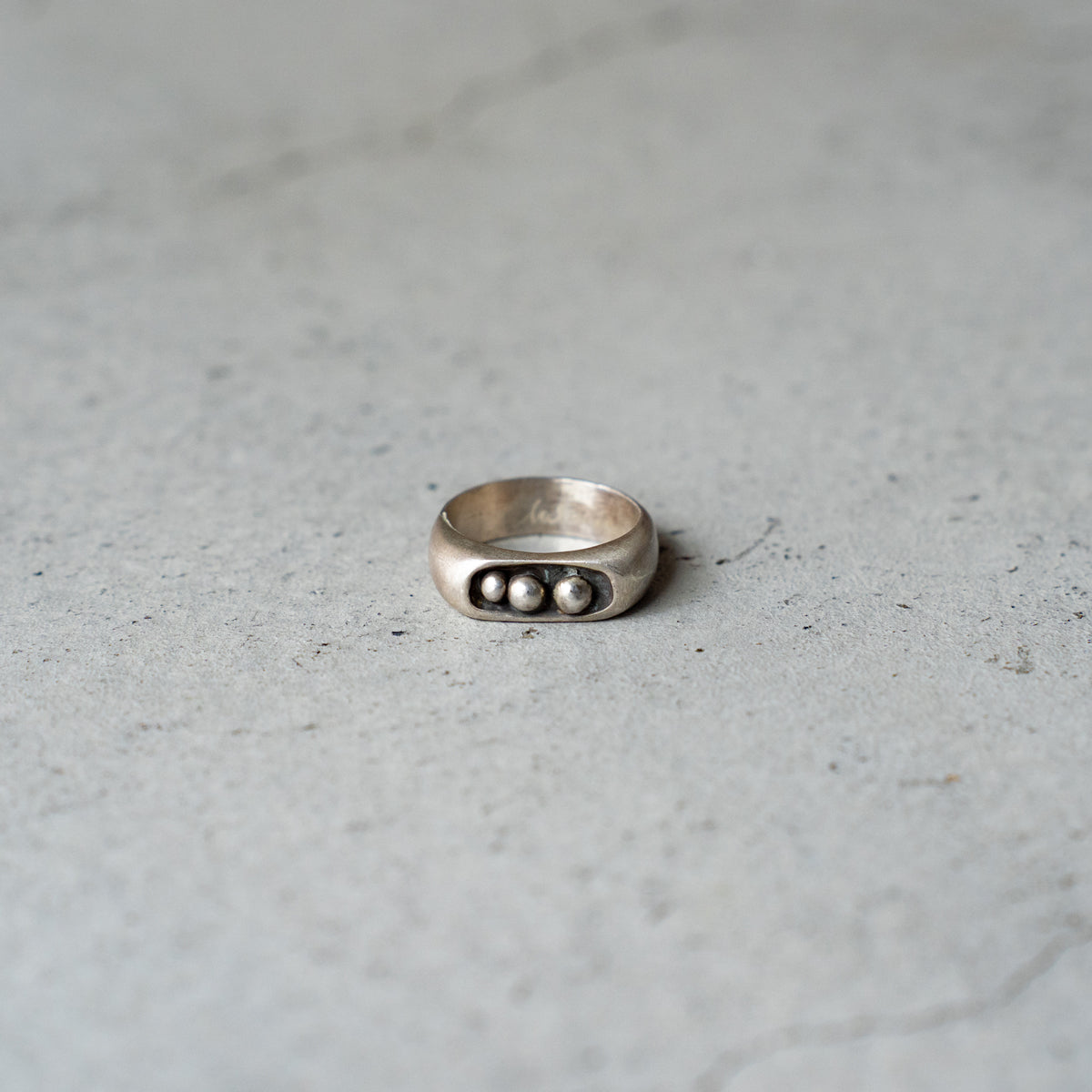 Melanie Decourcey  Silver ring with 3 freestyle silver balls inside oxidized center