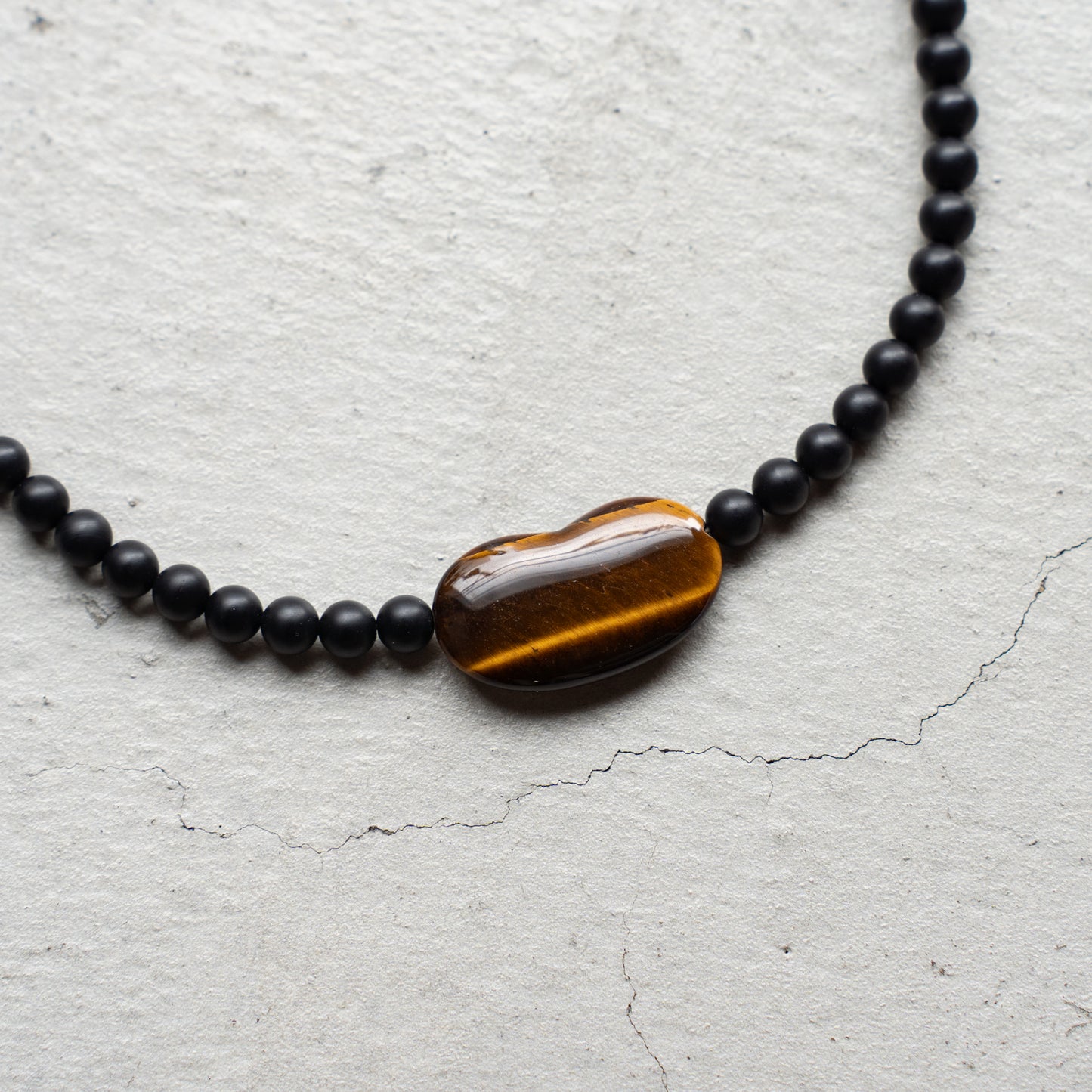 Melanie DeCourcey   Matte onyx with tiger eye heart center