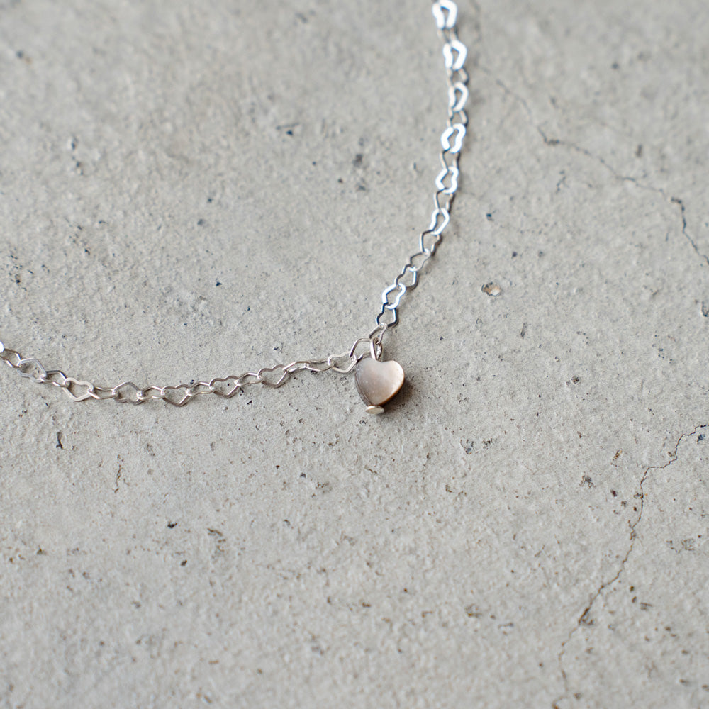 Melanie DeCourcey  Heart shape silver chain with small floating black mother of pearl heart