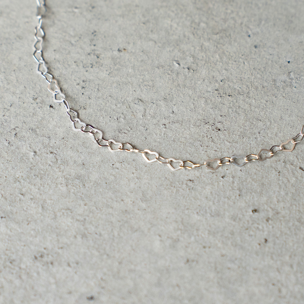 Melanie DeCourcey  Heart shape silver chain with small floating black mother of pearl heart