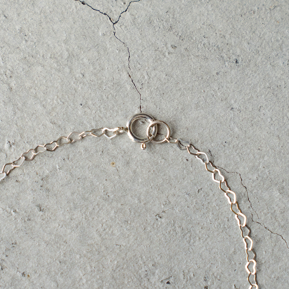 Melanie DeCourcey  Heart shape silver chain with small floating black mother of pearl heart